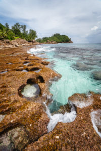 Old reef coastline and ocean waves on tropical Police Bay beach on Mahe Island, Seychelles. Old reef coastline and ocean waves on tropical Police Bay beach on Mahe Island, Seychelles.